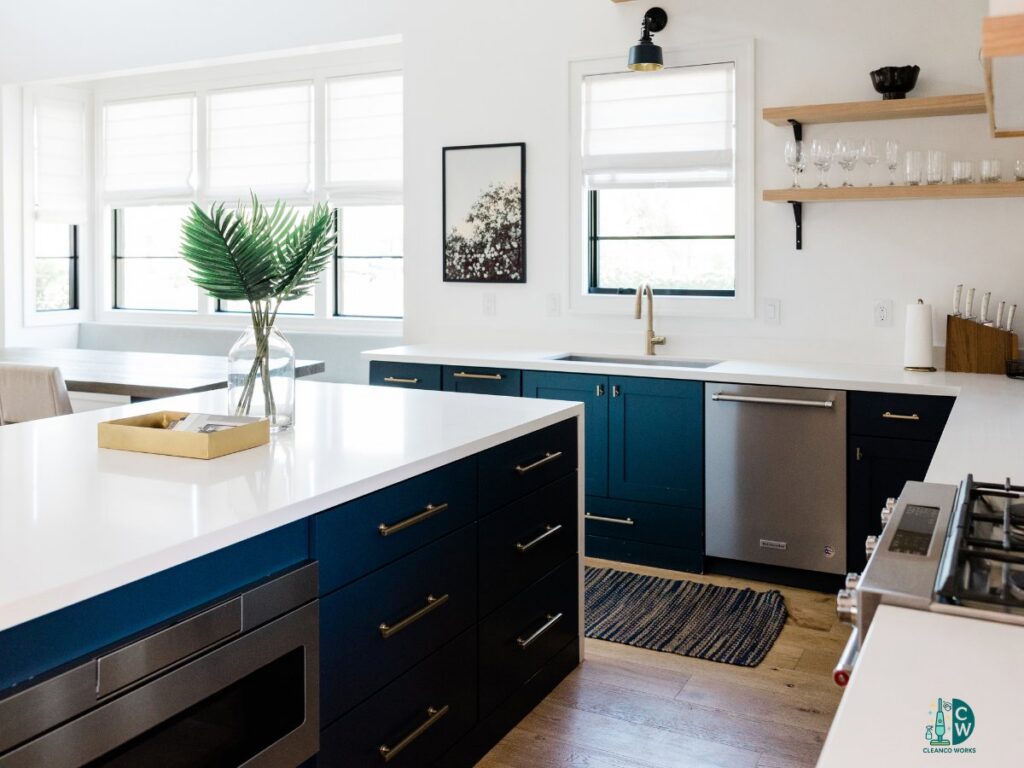 A modern and pristine kitchen with dark blue cabinets and white countertops, showcasing the excellent cleaning services of CleanCo Works in Scottsdale, AZ.