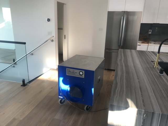 Dehumidifier operating in a modern kitchen and living area for water damage drying by Best Dry Flood and Mold Specialists, Inc. San Diego, CA