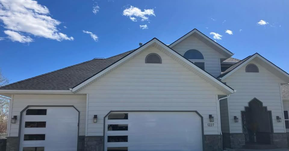 Modern white garage doors with horizontal windows installed on a residential home by Devildog Dock N Door in Helena, MT.