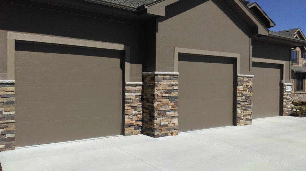 Two modern white garage doors with horizontal window panels, recently installed by JLM Garage Doors Omaha in Papillion, NE.