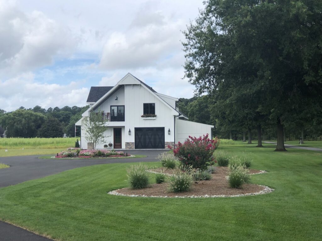 A modern white house featuring a stylish black garage door installed by Hickman Overhead Door in Milford, DE.