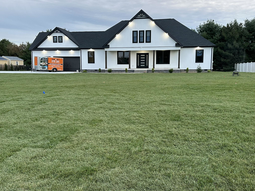 A modern white house with black trim and board and batten siding by Smart Siding LLC in Salisbury, MD