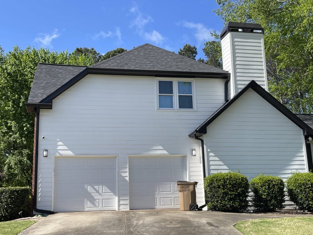 A modern house featuring crisp white siding and black trim installed by HP Exteriors in Woodstock, GA