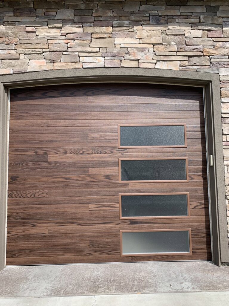 Modern wood-look garage door with four frosted windows installed by Garage Door Store Boise, ID.
