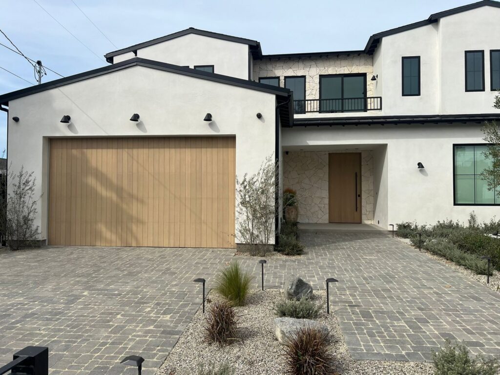 A modern house featuring a stylish wood-look garage door, a completed installation by Lifetime Garage Door in Las Vegas, NV.