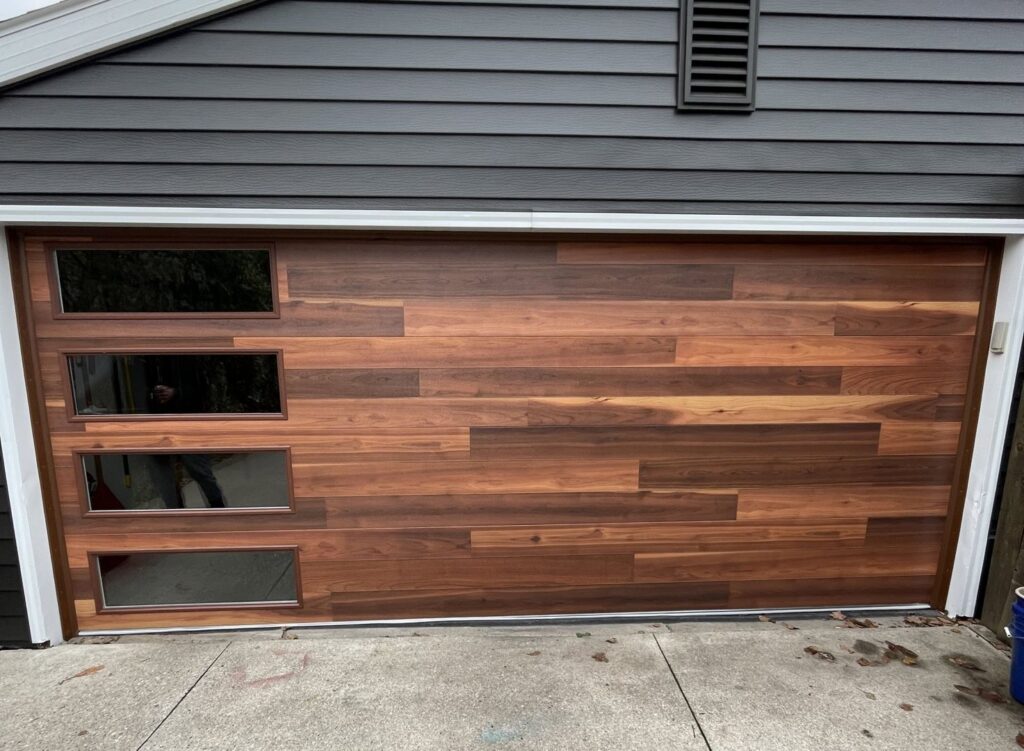 A modern wood-look garage door with horizontal windows installed by PS GARAGE DOORS in Grand Forks, ND