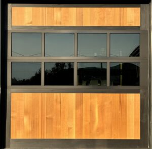 A modern garage door featuring wood panels and multiple windows, installed by Riverside Garage Doors in Kalispell, MT.