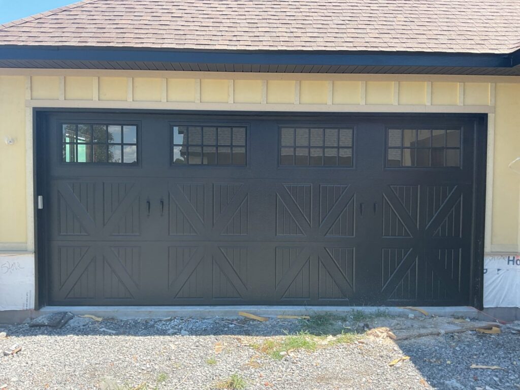 A modern wood plank style garage door installed by Fayetteville Garage Door Co. in Fayetteville, AR
