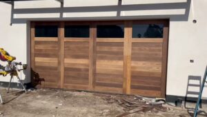 A modern wooden garage door with horizontal panels and windows, recently installed by NV Pro Garage Doors in Las Vegas, NV.