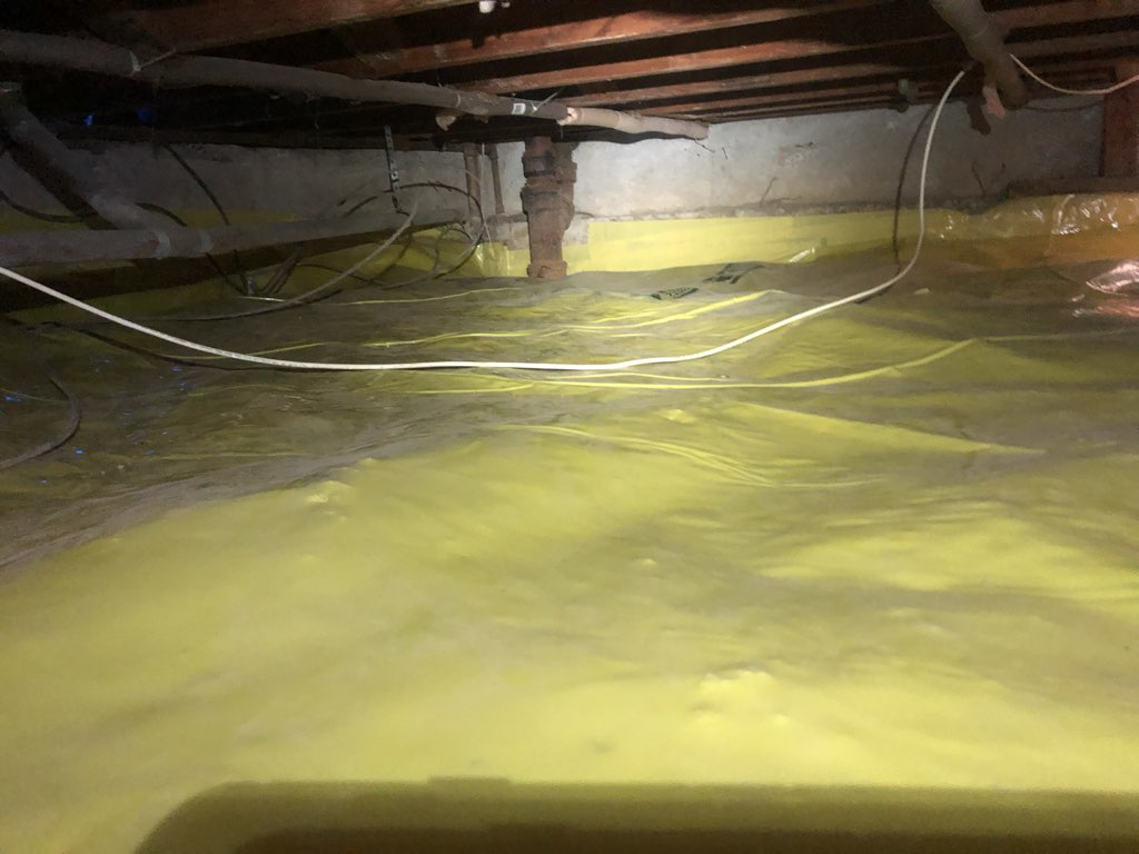 A clean crawl space with a yellow vapor barrier for moisture control by Bordi Restoration in San Leandro, CA