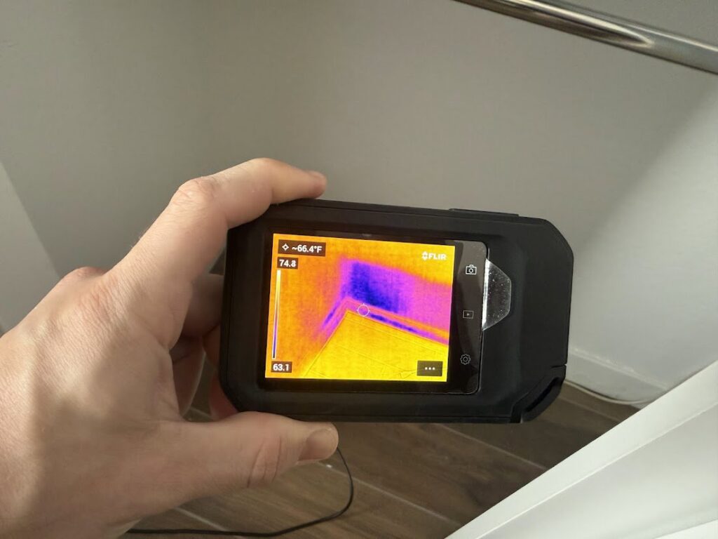 Using a thermal camera to detect moisture in a corner during water damage inspection by Flow State Restoration in Gilbert, AZ