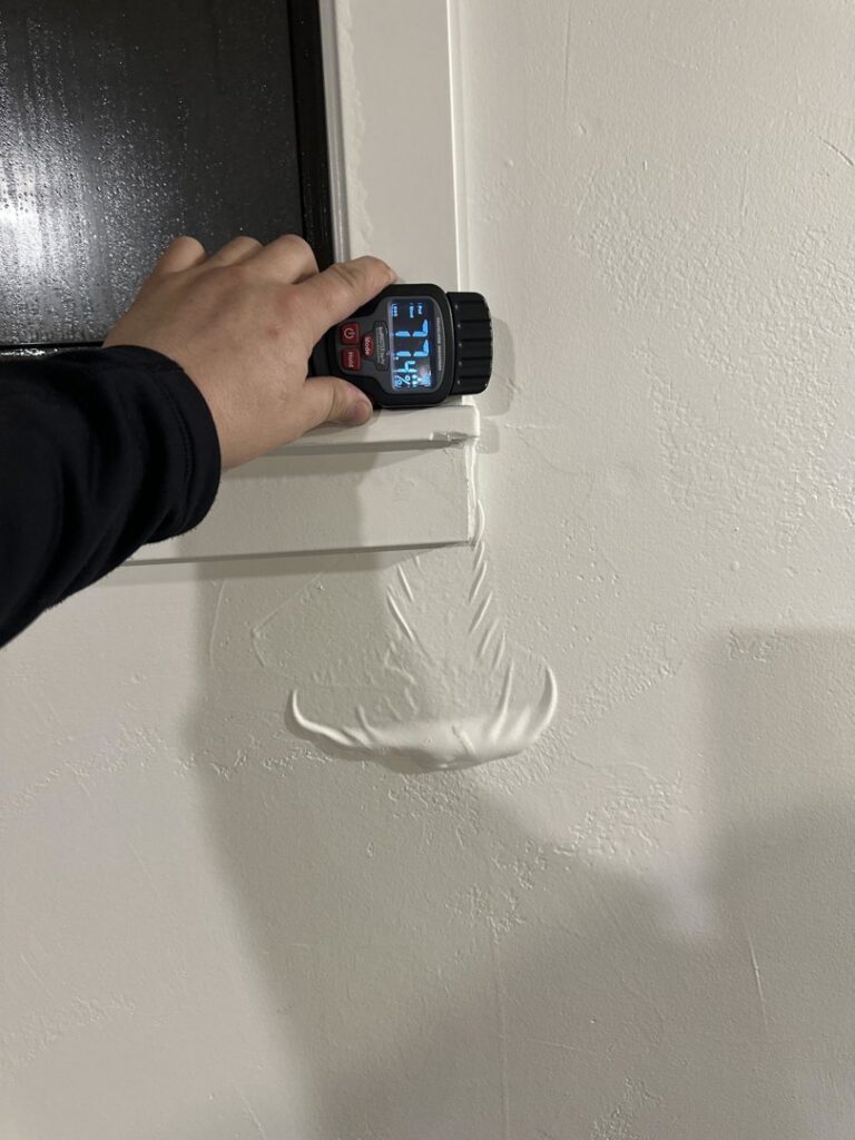 A moisture meter detecting water damage in a wall, showing a high reading, performed by Idaho Disaster Pros in Idaho Falls, ID.