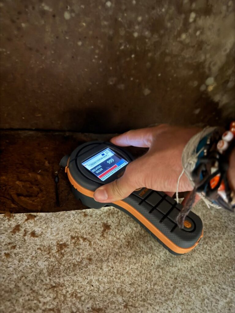 A moisture meter showing high moisture readings on a wooden surface, indicating water damage assessment by Restoration Specialist in O Fallon, MO.
