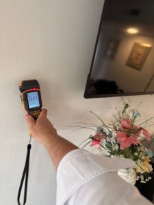 A technician using a moisture meter to detect hidden water damage in a wall at a property in Bluffton, SC, by PuroClean of Hilton Head.
