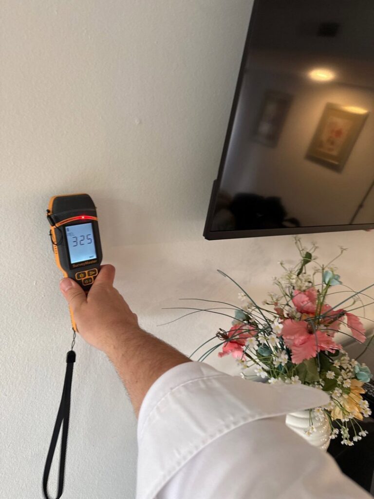 A technician using a moisture meter to detect hidden water damage in a wall at a property in Bluffton, SC, by PuroClean of Hilton Head.