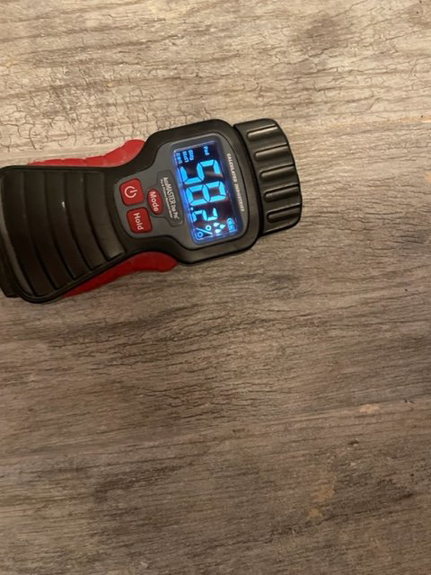 A moisture meter displaying a reading on a surface, used for water damage assessment by USA Water Damage Thunder Restoration in Coon Rapids, MN.