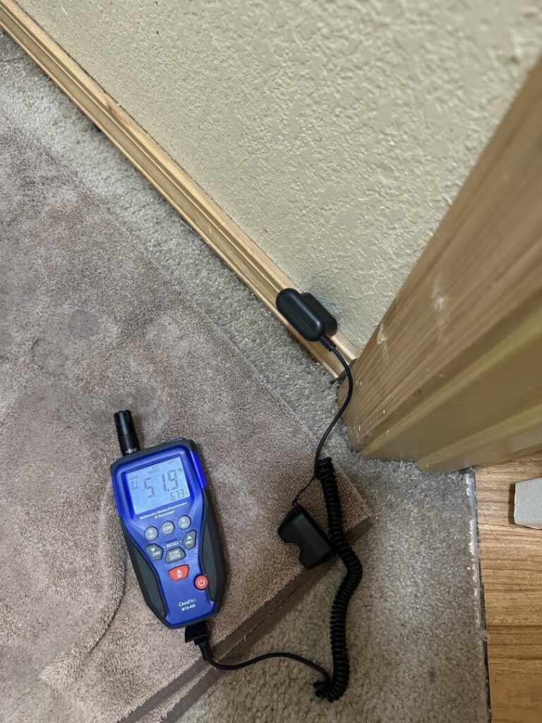 A moisture meter being used to inspect a wall for hidden water damage by Brothers Restoration in Post Falls, ID.