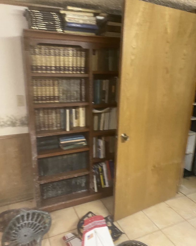 Mold visible on a wall and a wooden bookshelf, indicating water damage in a room, handled by 24HR Flood Pros of OKC in Oklahoma City, OK.