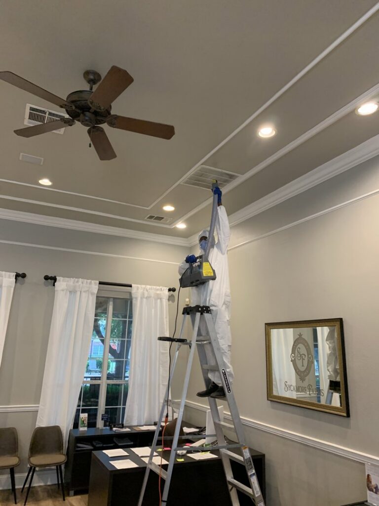 A technician in a hazmat suit performing mold remediation on a ceiling vent for Service Professionals in Edmond, OK.