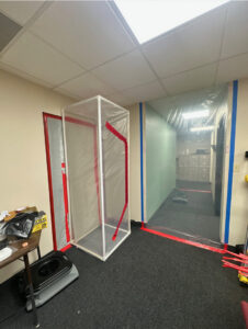 Plastic containment barrier in an office hallway for mold remediation by Built Different Restoration in Gilbert, AZ.