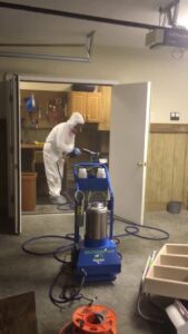 A Restored Air specialist in PPE performing mold remediation fogging in a garage in Summerville, SC.