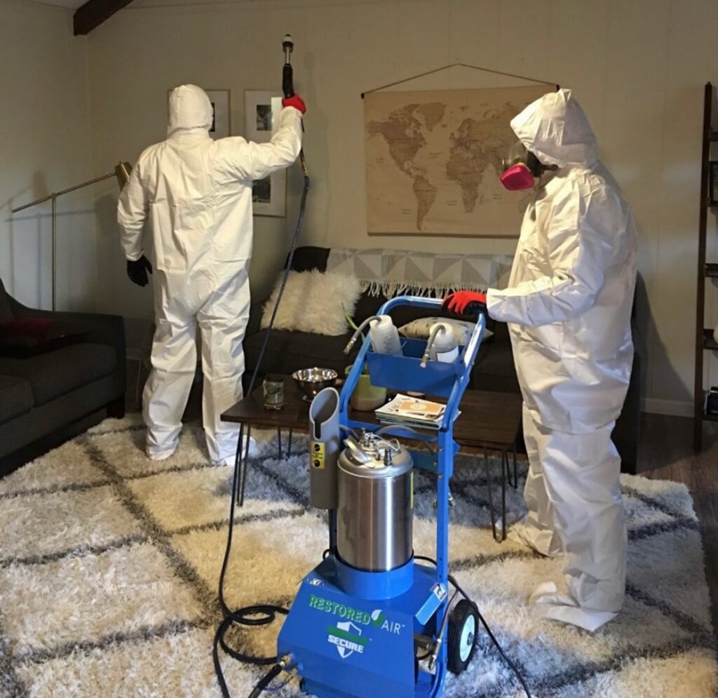 Restored Air specialists in full PPE performing mold remediation services in a living room in Summerville, SC.