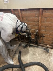 A technician in a hazmat suit performing mold remediation and water damage cleanup for Emergency Flood Team in Gilbert, AZ