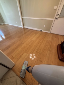 A mop cleaning a shiny hardwood floor, demonstrating services from Nova's Home Cleaning Services in Roanoke, VA.