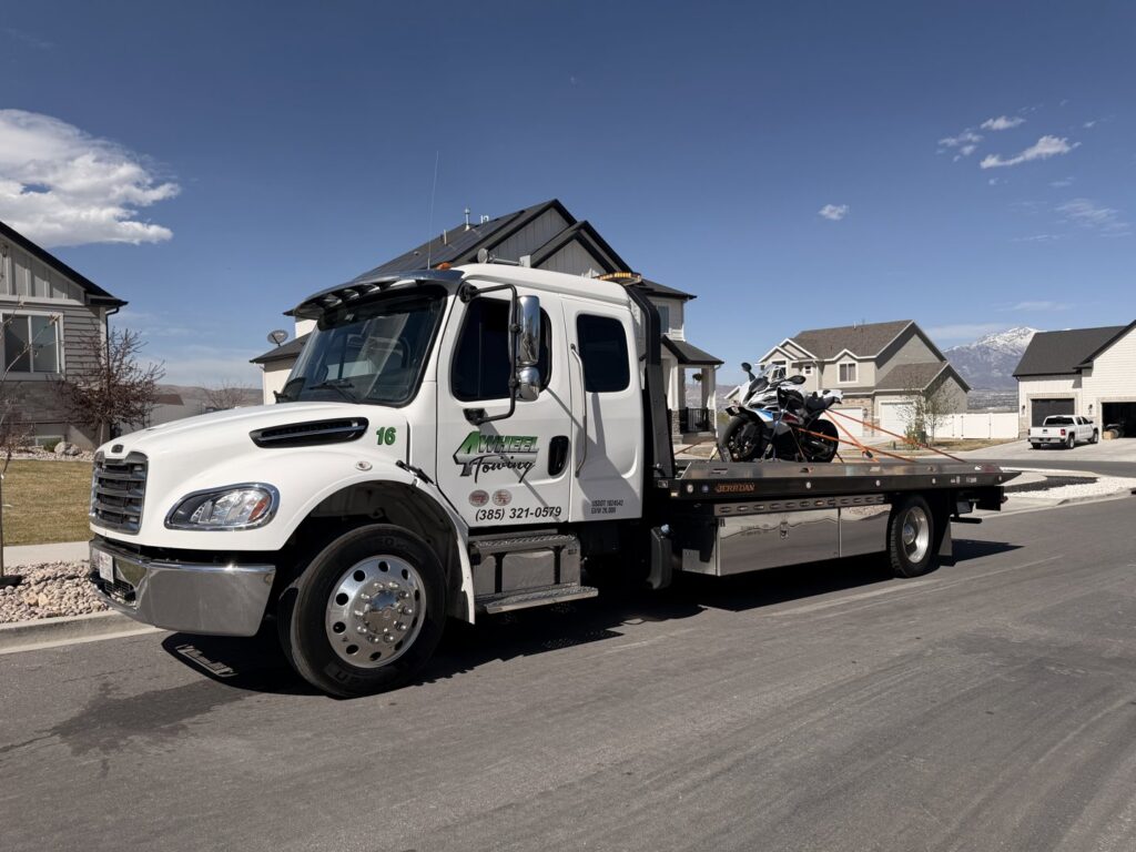 A motorcycle securely strapped onto a flatbed tow truck by 4 Wheel Towing in South Salt Lake, UT.