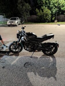 A black motorcycle being prepared for towing on a dolly by Bobbys Towing & Recovery in Raleigh, NC.