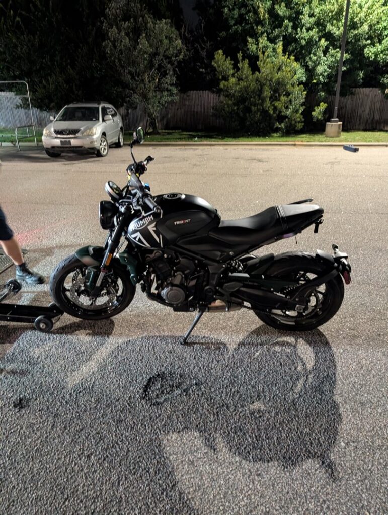 A black motorcycle being prepared for towing on a dolly by Bobbys Towing & Recovery in Raleigh, NC.