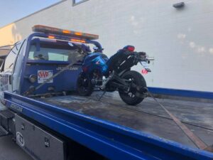 A motorcycle securely loaded onto a flatbed tow truck by 918 Wrecker Service in Tulsa, OK.