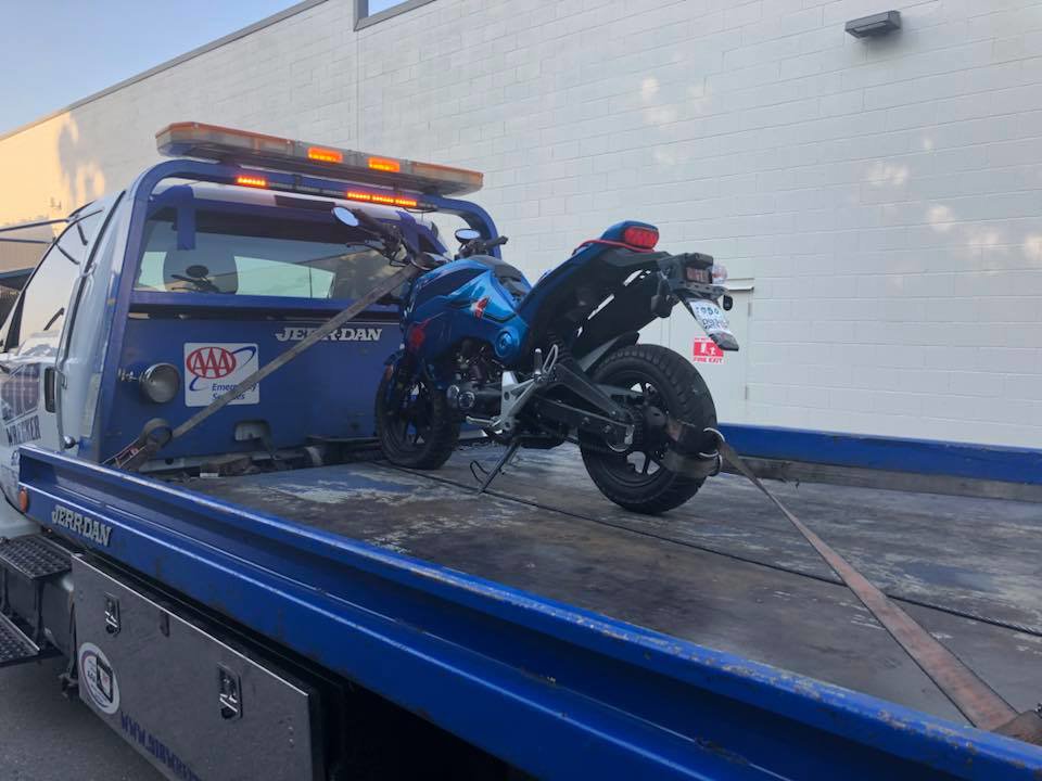 A motorcycle securely loaded onto a flatbed tow truck by 918 Wrecker Service in Tulsa, OK.