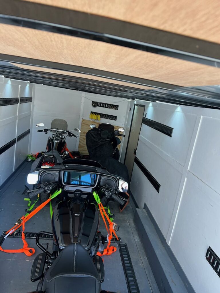 Two motorcycles securely strapped inside an enclosed trailer from B'ham Trailer Rentals in Alabaster, AL.