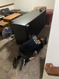 A professional mover from Next Step Moving carefully adjusting a large piece of furniture during a move in Eau Claire, WI.
