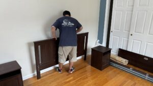 A Prime Moving professional assembling a bed frame as part of moving services in Boston, MA.
