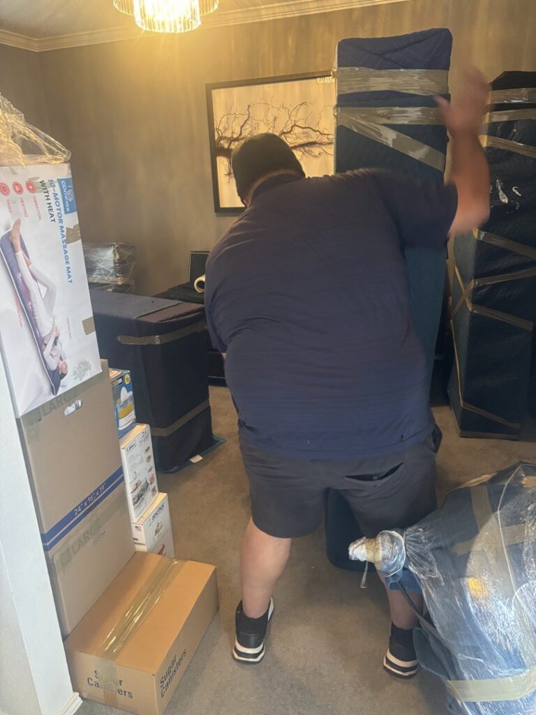 An Advantage Express Movers team member carrying wrapped furniture inside a home during a move in Arlington, TX.