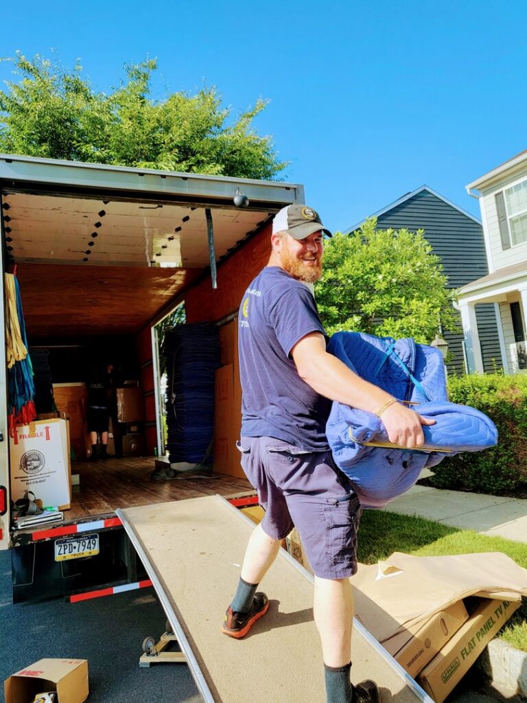 A mover carrying a wrapped item down a ramp from an S&P Network's Marathon Moving Solutions truck in Mechanicsburg, PA.