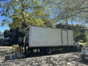 An Alto Moving mover loading a box onto a truck using a lift gate in Seattle, WA.