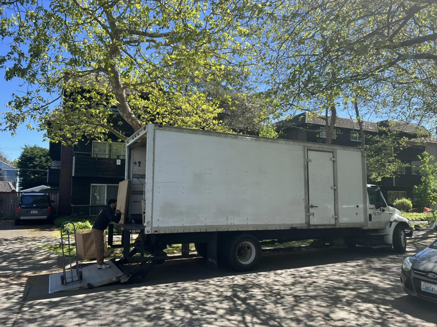 An Alto Moving mover loading a box onto a truck using a lift gate in Seattle, WA.