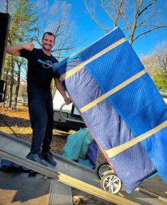 A Move Moore team member loading padded furniture into a moving truck in Grand Rapids, MI.