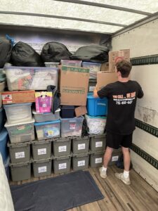 A professional mover from Next Step Moving loading a truck with packed boxes and bins in Eau Claire, WI.