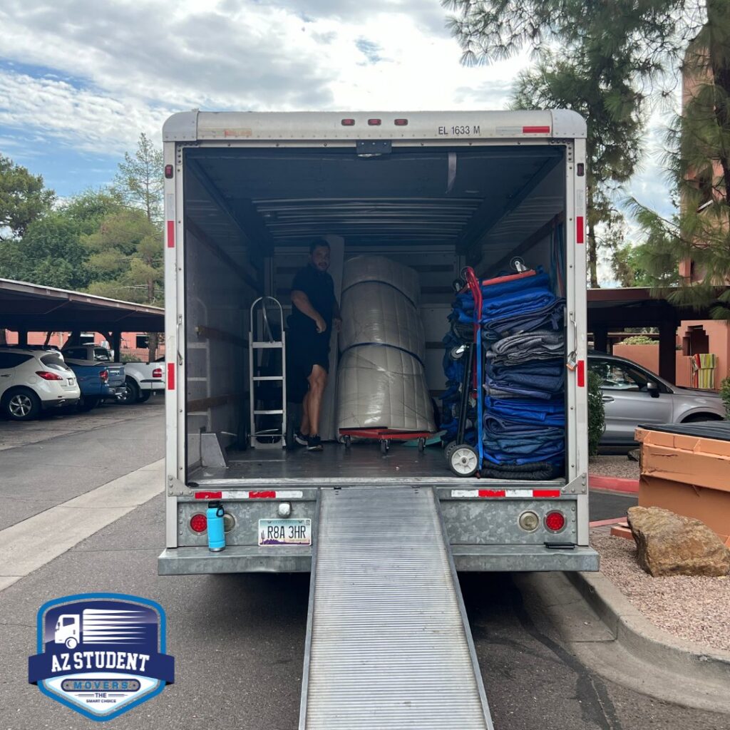 A professional mover loading a truck with wrapped furniture and moving blankets for Az Student Movers in Scottsdale, AZ