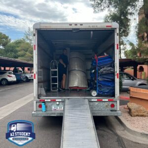 A professional mover loading a truck with wrapped furniture and moving blankets for Az Student Movers in Scottsdale, AZ