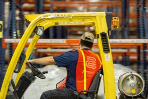 A mover from The Armstrong Company operating a forklift in a warehouse in Huntsville, AL.