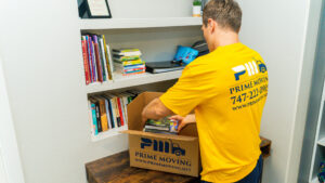 A Prime Moving professional carefully packing books into a branded box in Boston, MA.