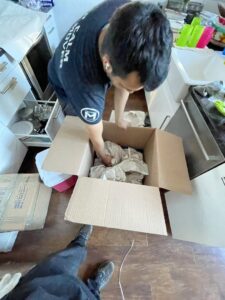 A J.Gentle Van Lines mover carefully packs kitchen items into a box during a moving job in Elizabeth, NJ.