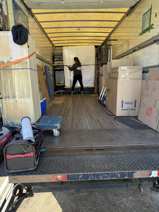A mover securing a mattress and boxes inside an Alto Moving truck during a job in Seattle, WA.