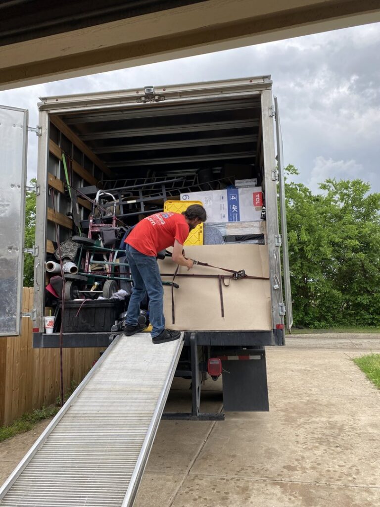A mover securing items on a ramp leading into a moving truck for Fatboy Slims Moving Company in Colorado Springs, CO.