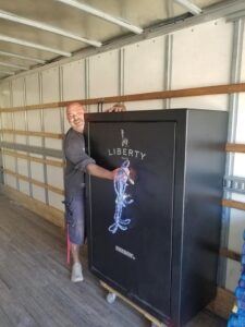 A mover transporting a large Liberty Safe inside a moving truck for First Class Moving & Storage in Phoenix, AZ